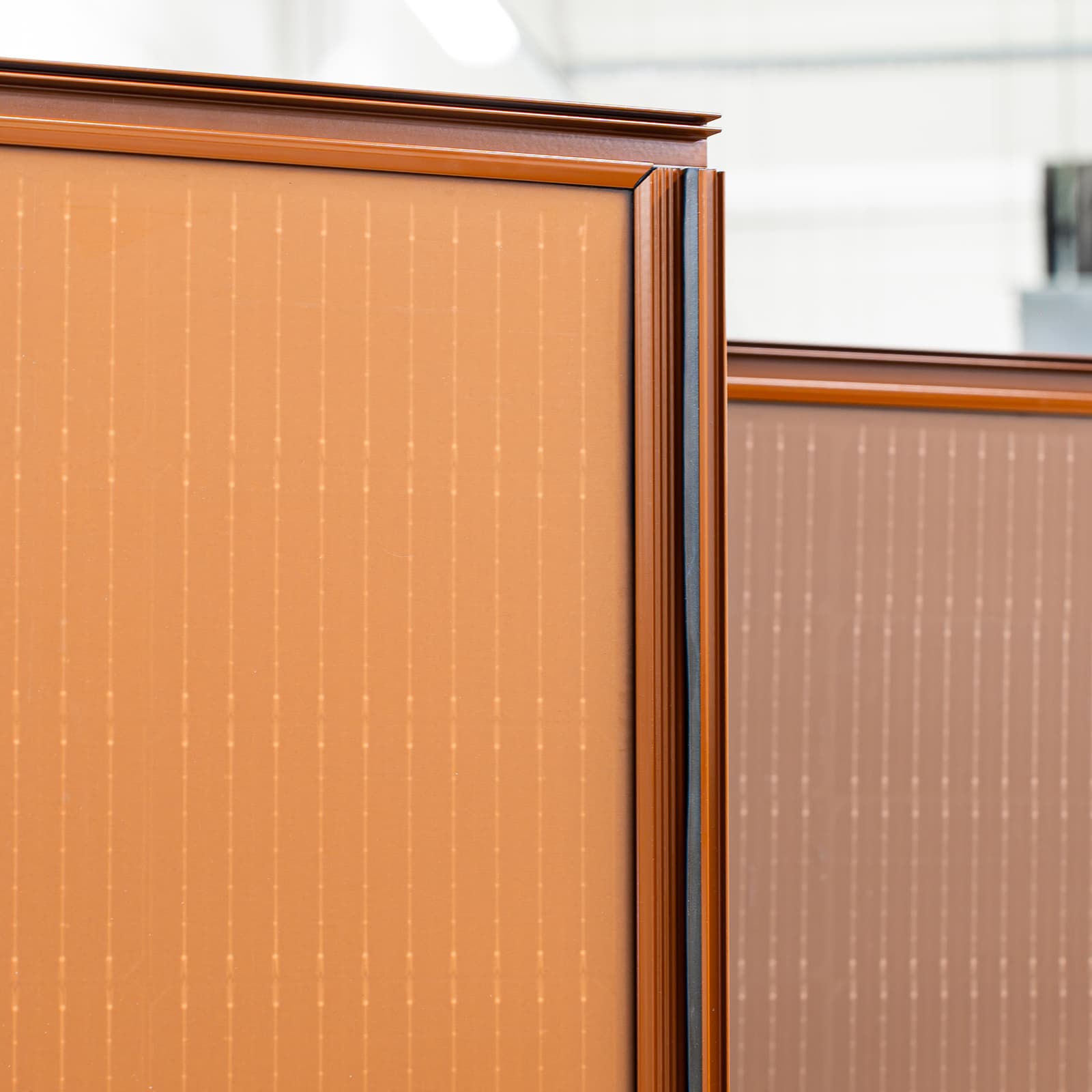 A close-up of a pitched roof covered with dark, integrated photovoltaic panels that form a smooth, uniform surface.