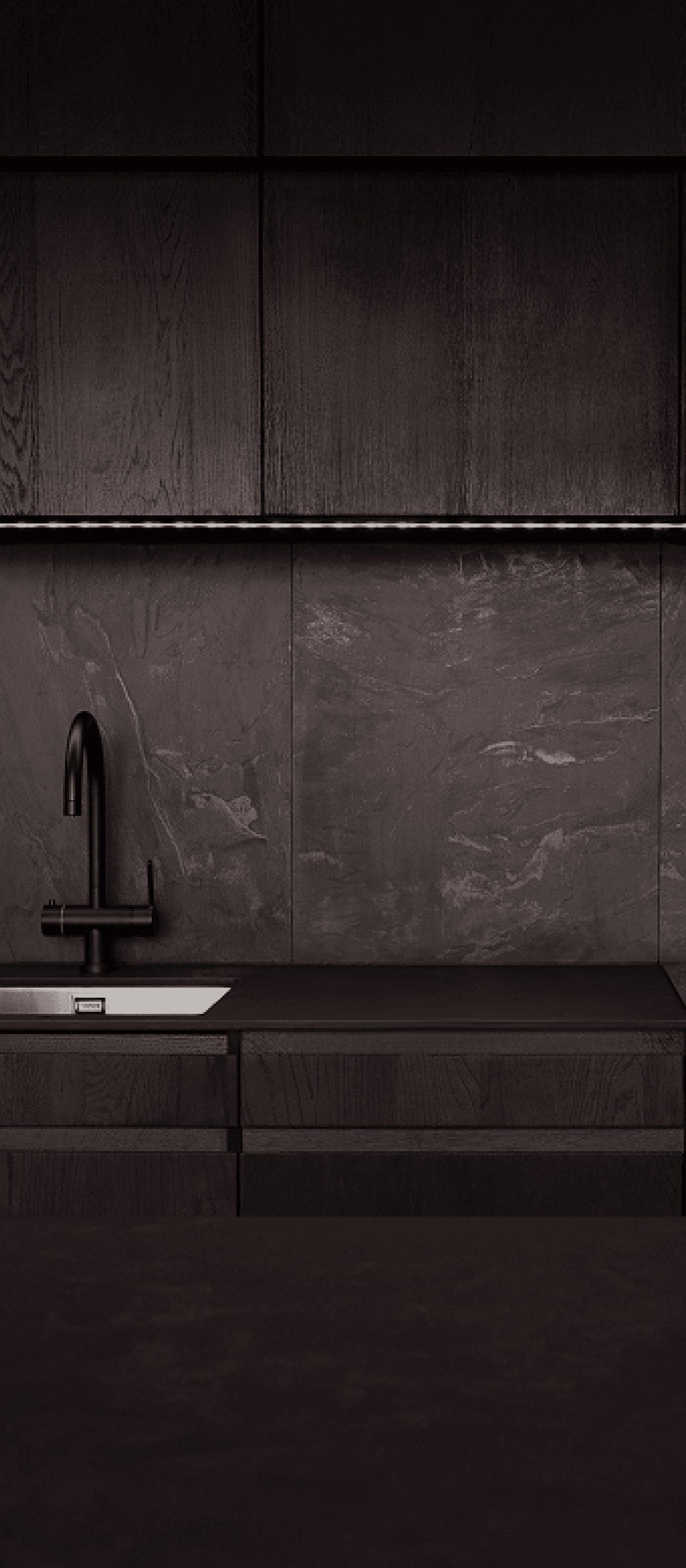 A dark Hombee kitchen with concealed cabinetry and a stone countertop.