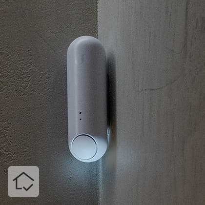 Close-ups of a textured, beige wall, with a white, oblong sensor mounted in the corner in the central part.