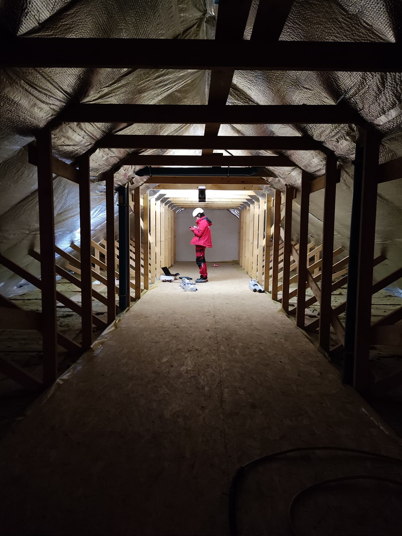 A Hombee specialist inspecting the timber roof structure and insulated attic during construction.