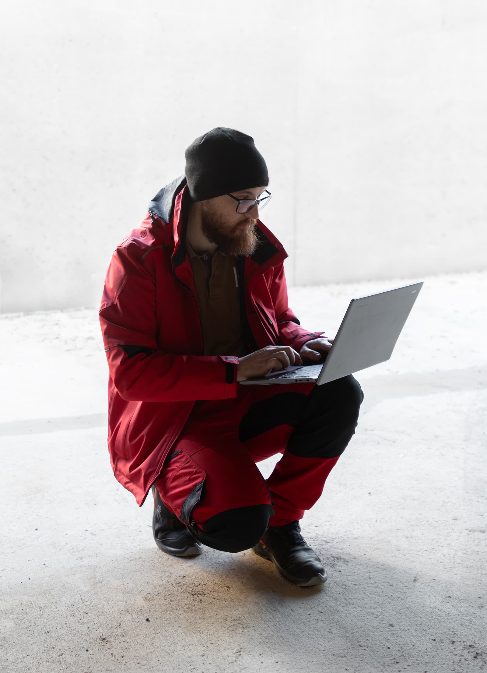 A Hombee specialist working on a laptop inside a building under construction.