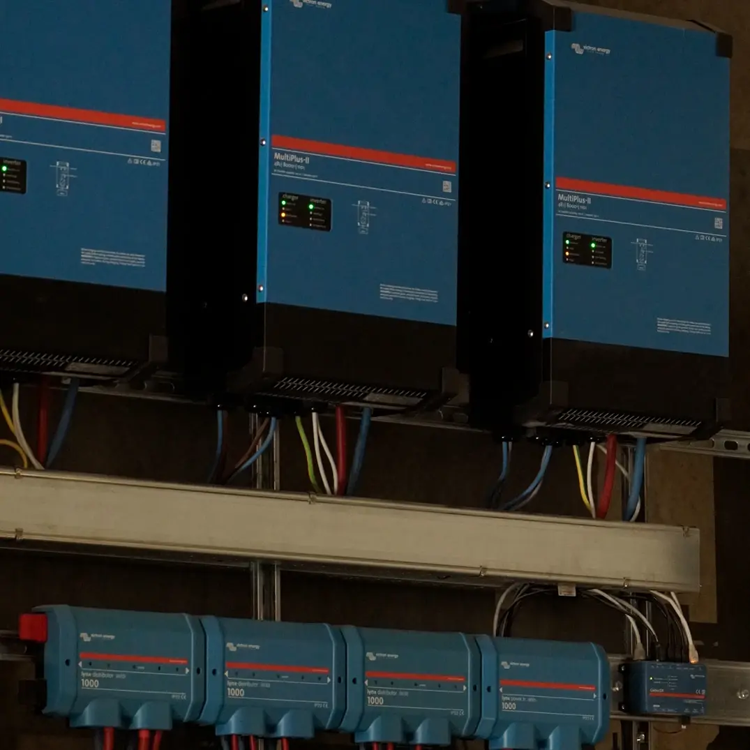 Three Victron MultiPlus-II inverters above Lynx distributors in a home technical room.